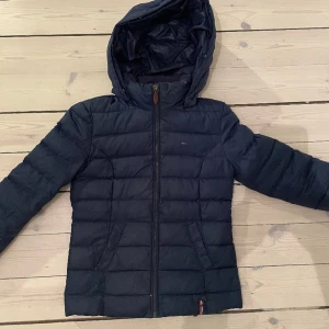 Tommy hilfiger Jacka - En så snygg dunjacka i storlek xs ifrånTommy hilfiger. Den är varm men också perfekt tjocklek eftersom den inte är för stor så man kan ha den mot hösten också. Den är i bra skick. 