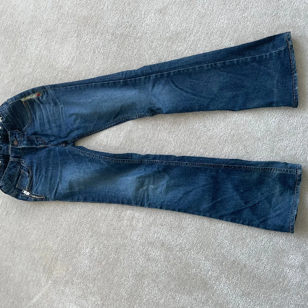 Säljer nu mina så fina lowwaist, bootcut jeans, med coola detaljer. Snygg mörkblå färg.  Midjemått: 36cm Innerbenslängd: 77 cm Skriv för mer info💕. Jeans & Byxor.