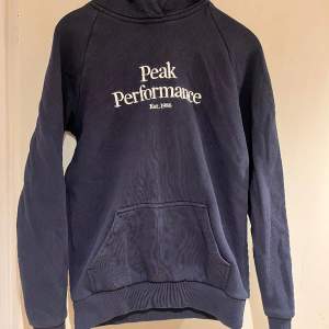 En marinblå peak performance hoodie i mycket fint skick. Storlek S. 