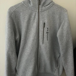 Sail racing zip hoodie - Säljer min Sail racing då den är för liten för mig! Är i väldigt bra skick men finns en liten defekt längst ner på armen som knappast syns. Se bild 4a. Skriv för mer information!