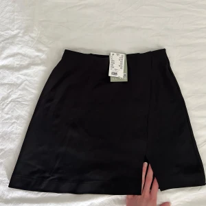 svart minikjol hm - helt ny och lapp kvar, kommer dock tvätta den innan jag skickar för den har legat i garderoben länge så tar bort lappen då. söt comfy vanlig svart minikjol! 