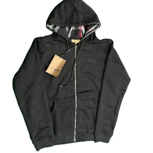  Burberry ziphoodie  - Svart burberry zip hoodie med rutig insida. Använd och tvättad en gång.  Mått: B 52cm, A 63cm, C 72cm