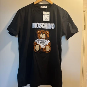 Helt ny tshirt strl M "Moschino" - Helt ny och oanvänd med lappar kvar, storlek M. Vet ej om den är orginal.