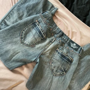 Vintage Gina tricot jeans - Fina lågmidjade vintage Gina jeans med coola rosa detaljer, fint sick. Säljer för att de inte kommer till andvändning 💞