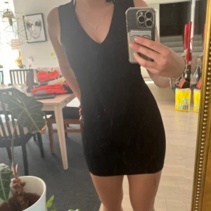 Tight svart klänning  - Säljer en jättesnygg tight klänning med V-ringning från märket ”Coolcat” i storlek Xs.   //Tilda