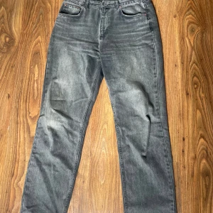 Gina Tricot Jeans - Säljer dessa gråa jeans från Gina Tricot. Dom är baggy (lite som mom jeans) men går lite inåt vid fötterna, dom är även högmidjade. Storlek 42. Använda men i bra skick. Liten defekt vid fötterna (de sista bilden). Köpte för 599kr, säljer för 150kr.💕