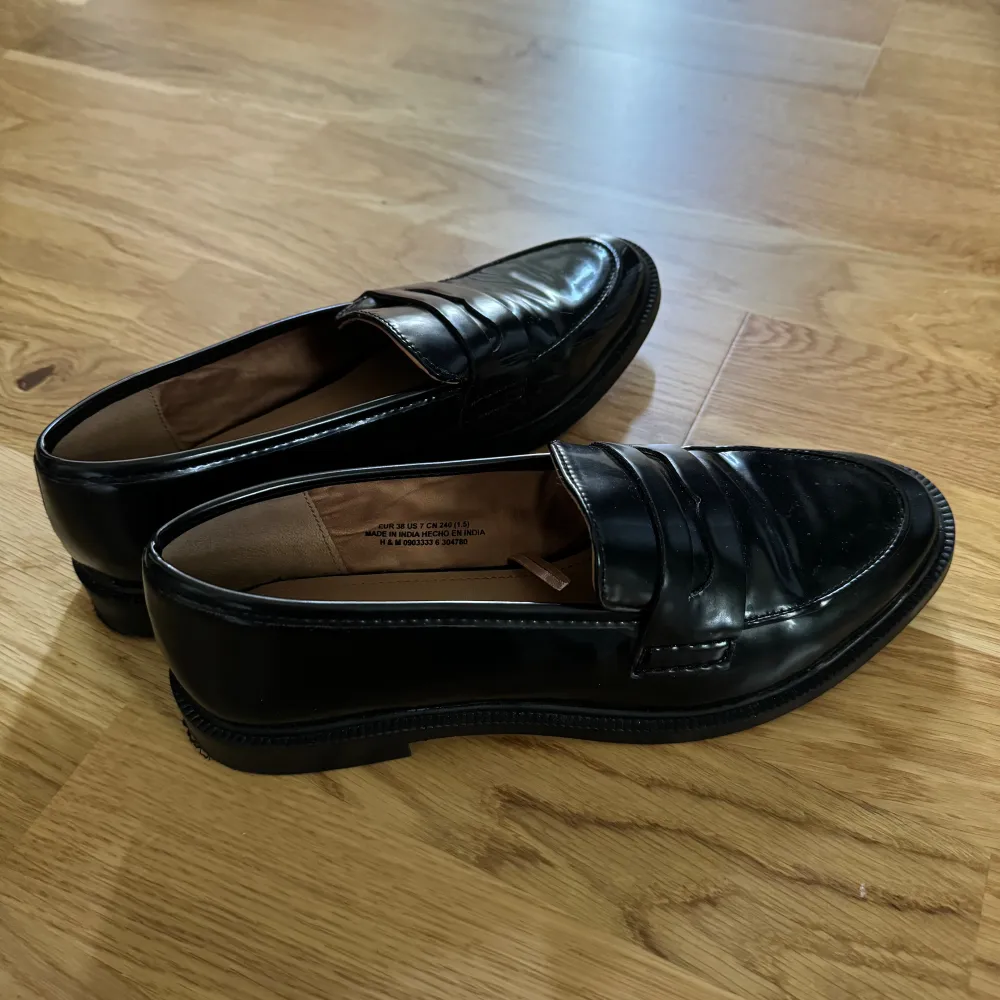 Ett par svarta loafers från hm. Aldrig används och ser ut som nya. De är svarta, typ lackade, med liten klack. . Skor.