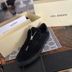 Helt svarta axel arigato, skicka prisförslag.  - Säljer ett par svarta Axel Arigato Laceless i storlek 44. Skorna är i bra skick, betyg 7 av 10, och kommer rena. Tyvärr följer inte lådan med, men en godiebag följer med som bonus! Perfekta skorna för sommaren o fester. 