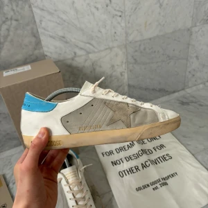 Golden Goose Skor - Säljer nu dessa feta Golden Goose skorna i den eftertraktade modellen ”Superstar”. | Storlek: 43 | Skorna har endast använts 5 gånger ~ 9.5/10 Skick | Nypris: 6000 kr | Allting på bild 5 tillkommer. | Svarar gärna på era frågor :)