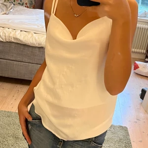 Vit topp - Vit blus från sisters i storlek XS, passar som S. Lite slitet på framsidan sommar syns på första bilden och en liten fläck på baksidan (går nog att bleka bort) som finns på andra och sista bilden. Fint skick i övrigt. Använd gärna köp nu!
