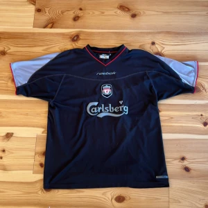 Liverpool Tröja - Säljer denna sjukt feta sällsynta Liverpool vintage tröja fr säsongen 2002-2003. Tröjan är i storlek L men skulle säga att den passar M om man föredrar en lite större tröja. Skicket är bra för sin ålder men med tecken på användning visat på bilderna.