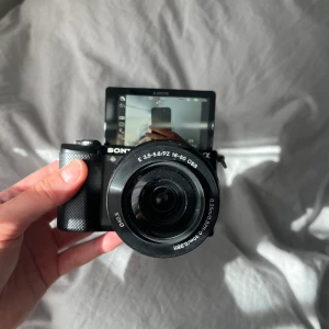 Kamera - Säljer min kamera Sony a5000.  Kan användas både till foto och film. Har viewfinder som kan både fällas upp och användas nerfällt, se bilder.  Ingår: Kamera, kameralins, linsskydd, kameraväska med band och laddare.   Nypris 3500kr, bra skick 🙌🏼💕