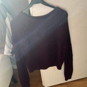 En vinröd stickad tröja som är croppad och jag flätade designer på sidorna av armarna. Tröjan är i väldigt bra skick och är använd 1-2 gånger