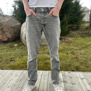 Gråa Jeans 34/32 - Ett par feta grå jeans från Zara i straight-modell. Jeansen är i princip i nyskick bortsett från ett litet hål i ena fickan. Jeansen kommer inte till användning längre då de har blivit för små. Jeansen sitter som en storlek 34/32