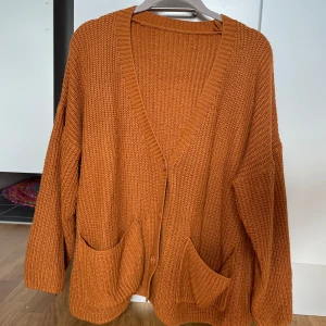 Orange stickad kofta - Gullig och varm stickad kofta med knappar på framsidan. Sitter lite oversize men är i strl s. 