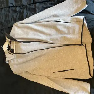 Ljusgrå peak performance hoodie med passform M. 
