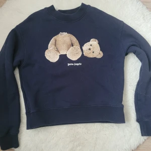 Palm Angels Kids Teddy Bear - Mörkblå Palm Angels Teddy Bear tröja i barnstorlek 10. Mycket fint skick. Hör gärna av dig om fler bilder eller frågor.