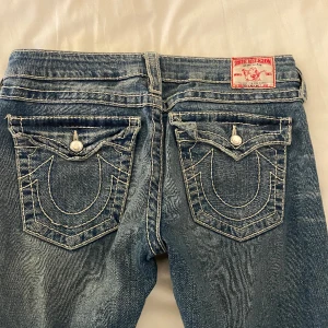 True Religion Jeans - Säljer mina trueys då dom tyvärr inte passar på mig (bild är från förra säljaren). Jeansen är low rise och bootcut och har inga synliga defekter!   Midjemått-40 cm rakt över Innerbensläbgd-ungefär 85cm 💓