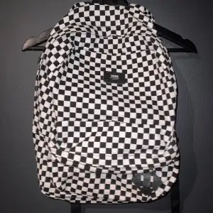 En ryggsäck med checkered mönster på. Har använts ett antal gånger. Väskan har lite tecken av användning vid strapsen (se bild). 