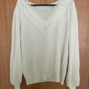 Vit tröja - Vit långärmad tröja, med fint mönster i V ringningen, inga defekter, vet inte var den är ifrån då det inte finns någon lapp och kommer inte ihåg men skulle säga den är storlek M/S?