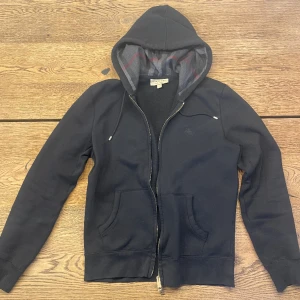 Burberry Hoodie - Svart burberry hoodie. Den är självklart äkta men har tyvärr inget kvitto för den var köpt för länge sen men har knappt använts. Skick 9/10. Storlek M men passar S. Tveka inte på att höra av dig om du har några frågor.