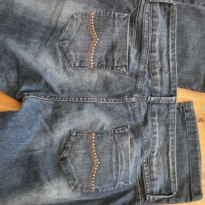 Lågmidjade jeans - Lätt utsvängda, lågmidjade jeans. Benlängd 102. Storlek såsom 40/42.