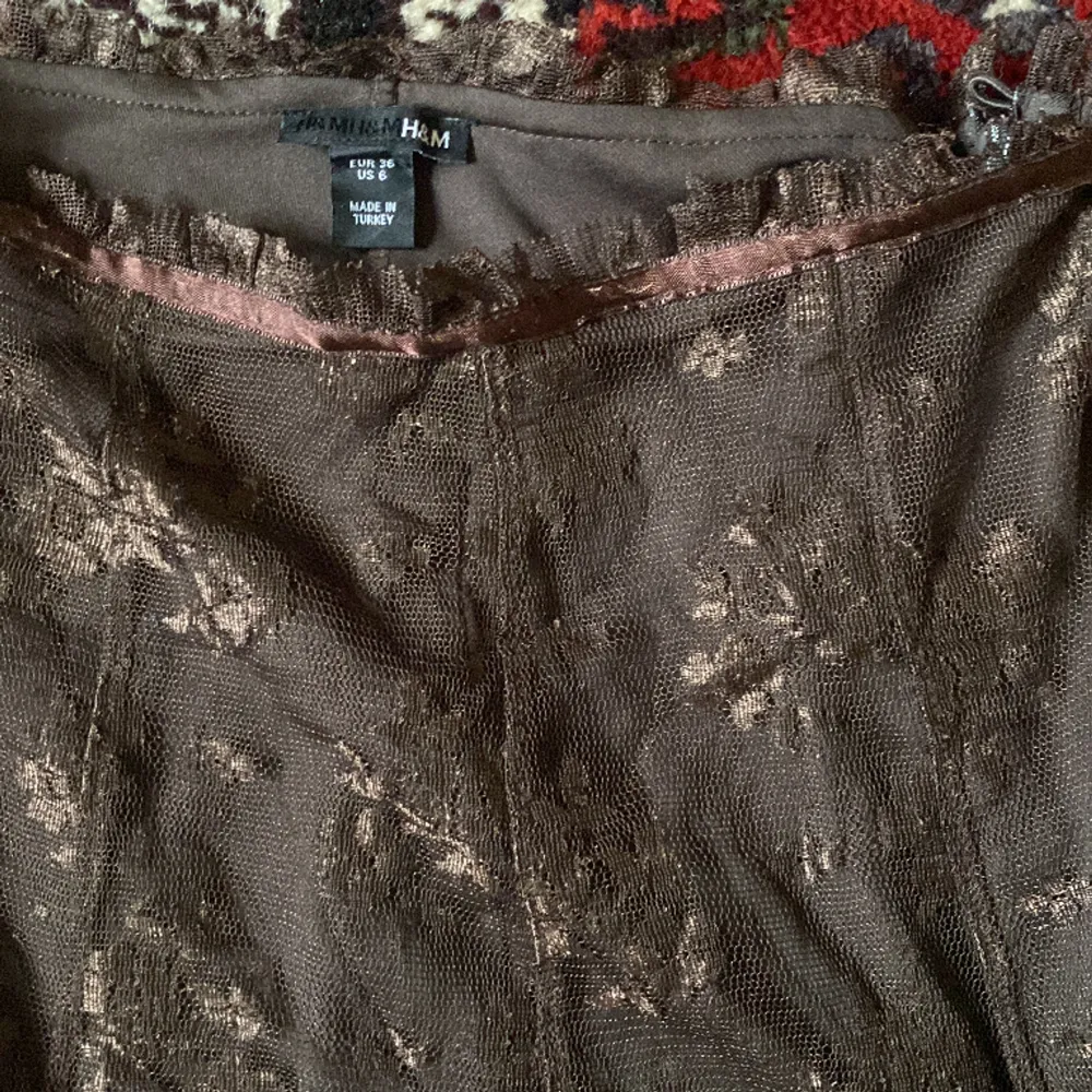 brun midikjol med blommig spets, knälängd och lågmidjad.. Kjolar.