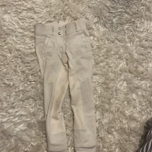 Vita ridbyxor  - Säljer mina vita ridbyxor då de inte kommer till andhämtning. Dom är använda fåtal gånger och dom har bling detaljer och är i storlek 34 