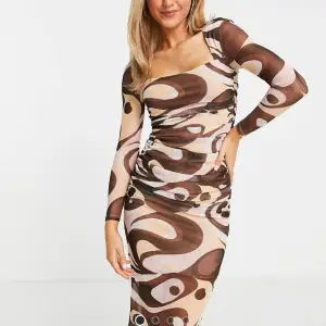 Snygg klänning i mesh med brunt/rosa/nude färgat mönster. Använd två gånger. 