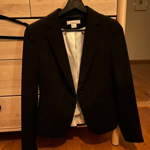 Figursydd kavaj - Säljer en svart figursydd kavaj från H&M i storlek 36. Endast använd ett fåtal gånger. Fint skick. 
