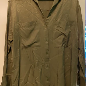 Viskosskjorta från H&M - Damskjorta i storlek 38 i olivgrönt. Använd men felfri.