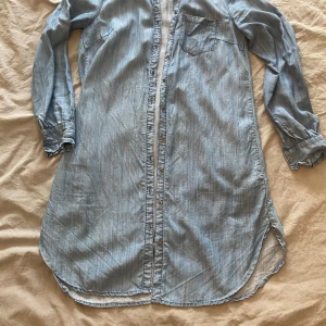 Klänning/tunika - En tunika i tunn jeans material. Knappar hela vägen . 