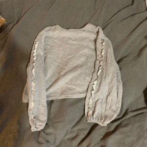 Sweatshirt från Cubus  - Grå sweatshirt från Cubus i storlek m med volanger på ärmarna 