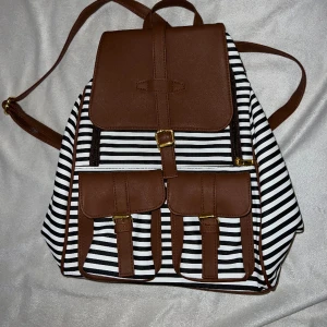 Ryggsäck - Randig ryggsäck med bruna och guldiga detaljer. Från Thailand. 