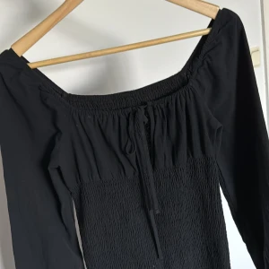 Off shoulder klänning med snören och öppning  - Super söt off shoulder klänning med öppning i mitten med snören som man knyter själv och kan justera. Storlek 38/M men mer som en S/XS. Töjbart material. Använd gärna bundle köp funktionen 🖤🌸😻💗