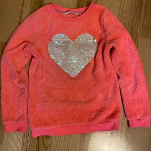 Tröja med paljetter  - Fluffig tröja, strl 134/140. Kolla gärna in mina andra annonser för samfrakt. Jag säljer mycket barnkläder just nu! Katt finns i hemmet (allergivänlig ras).