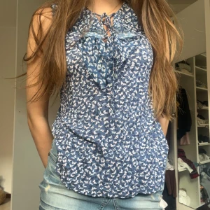 Volang topp - Blå Stockholmstil volang topp. Den har öppna armar och man knyta en rosett vid bröstet. Super söt och perfekt inför sommaren ❤️