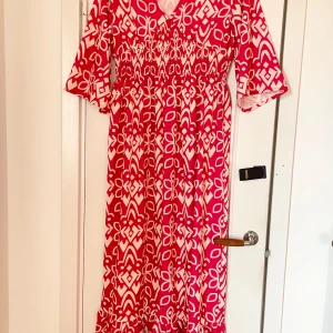 Maxiklänning med tulpanärm - Maxiklänning med resår i midjan Volang nedtill samt tulpan ärmar Stl M  Aldrig använd då den tyvärr var för stor