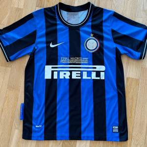 Inter Milan hemmatröja från 2009/10 säsongen med Champions League Finalen broderat på tröjan. Diego Milito på ryggen. Använd nån enstaka gång tröjan är i nyskick! Är 180 lång och den är lite liten i storleken