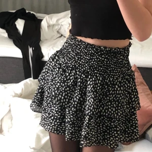 Kjol från Chelsea  - En jättefin svart kjol med vita prickar från Chelsea. Som ny endast använd fåtal gånger. Storlek S men passar både större och mindre då det är resår i midjan. Skriv för funderingar (LÅNAD BILD)