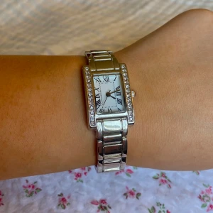 Silvrig klocka - Säljer en klocka köpt second hand. Den är aldrig använd och är i nyskick. Den har nytt batteri i och klockans storlek går enkelt att justera hemma. Manual tillkommer.