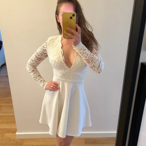 NLY ONE klänning  - Säljer min otroligt vackra klänning från NELLY. Den är ben-vit och ganska tjock i materialen, med spets på armarna. Storlek XS. 