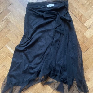 Kjol Boli - Tyllkjol från Boli i Köpenhamn. Använd en gång. Prickig, svart. Knyte i fram. 