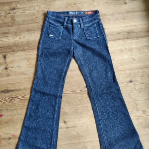 Vintage lågmidjade jeans - Ett par vintage jeans från y2k, de är lågmidjade, bootcut och har massa fina detaljer! Säljer för att de är för små på mig. Alldrig använda av mig och ser helt nya ut<3