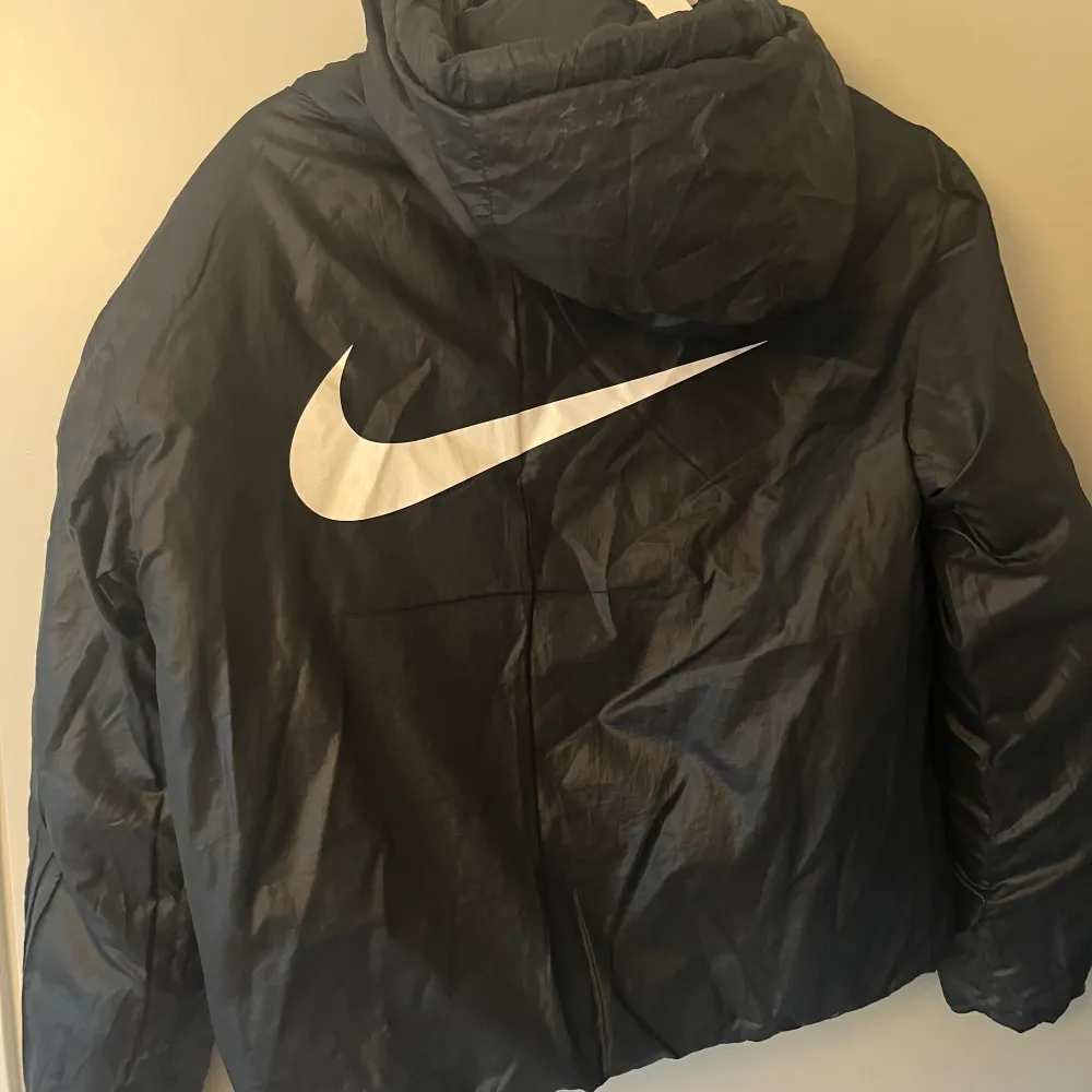 Jacka från Nike. Använd med i bra skick. Säljer då den inte kommer till användning. Går att vända ut och in på den. Notera att den har några fläckar på armen och ryggen! Går säkert bort i tvätten. Osäker på storlek men passar som M. 😊. Jackor.