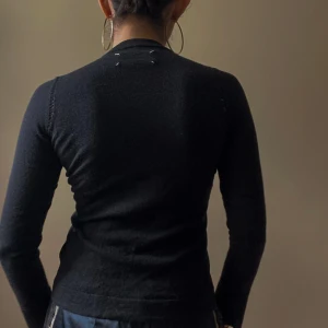 Maison Margiela Black Knit Open Stitch Sweater - Preloved Knit Sweater With Open Stitch Detail Around Shoulders. Made In Italy.  Good Condition.  Model Is 160cm (5”3) And Generally Fits XS/S.  52 CM/ 20.5 IN Length 56 CM/ 22 IN Sleeve 26 CM/ 10.2 IN Shoulders 76 CM/ 29.9 IN Chest 72 CM/ 28.3 IN Waist  