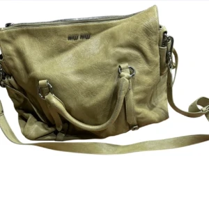 MIU MIU BOW BAG - Väska från MIU MIU köpt på Vestiaire tidigare i höst. Knappt använd, väldigt bra skick! I läder och färgen pistachio, äkthetsbevis och dustbag finns. Köpt för 3650kr💚 MÅTT: BREDD: 37 cm HÖJD: 29 cm DJUP: 15 cm  Skriv privat för fler bilder.