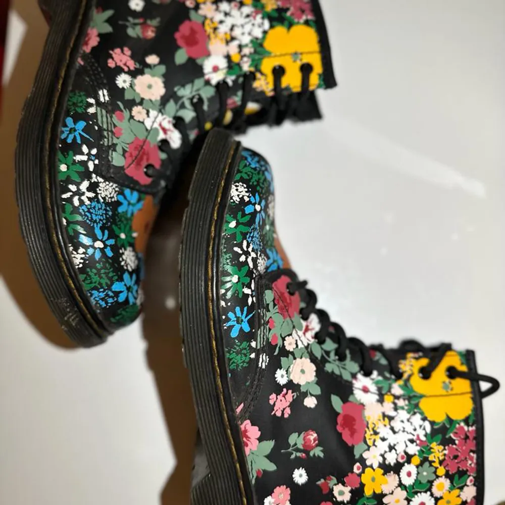Dessa Dr.Martens skor är använda men i ny skick. Blommig design med 2 olika sidor på varje sko (Bilder finns på båda sidor). Tål vatten och passar bra till vintern. Passar bäst med svarta jeans. Storlek: EU 36/ 2 UK/ 3 US. Skor.