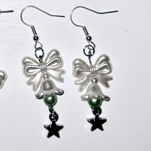 Grön med klocka - Vita akrylpärlor med vit akrylklocka med grön akrylpärla i och silvrig stjärna. Silvriga örhängen (ej äkta silver, ej nickelfria) 