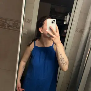 En blå klänning. (Det är spegeln som är smutsig, inte klänningen!)